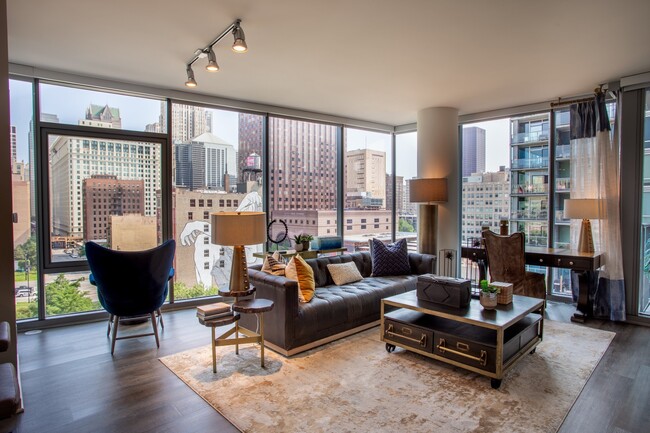 Sala de estar con ventanales de piso a techo en The Grand Central Apartments en Chicago, IL 60607 - The Grand Central