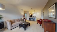 Located at 1200 N 62nd St in Wauwatosa, Wisconsin, this single-floor residence offers a well-designed open-concept layout that seamlessly connects the main living spaces. The living room is generously sized, featuring plush wall-to-wall carpeting, neutral-toned walls, and multiple windows that invite ample natural light and views of the surrounding neighborhood. A door provides convenient access to an outdoor area directly from the living space.

The kitchen is a standout feature, appointed with warm wood cabinetry, granite countertops, stainless steel appliances including a refrigerator, range, and built-in microwave, and hardwood flooring. A large granite-topped island with bar seating serves as both a functional workspace and a casual dining area, accented by stylish pendant lighting overhead. The kitchen flows openly into the living and dining areas, making it ideal for entertaining.

The bedroom is a quiet, carpeted retreat with multiple windows offering outdoor views and ample wall space. A hallway connects to the full bathroom, which features a dual-sink vanity with rich wood cabinetry, light countertops, tile flooring, and a separate shower. The overall design is clean, modern, and functional, with a cohesive neutral palette throughout.