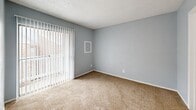 Located at 1400 Gardina St in San Antonio, TX, this efficiently designed one-bedroom, one-bathroom unit offers a practical and comfortable layout across a single floor. The open-concept living and kitchen area is anchored by warm hardwood-style flooring and a textured ceiling, creating an inviting atmosphere. The kitchen is well-appointed with white cabinetry, white appliances including a refrigerator and dishwasher, a double sink beneath a window, and a marble-patterned breakfast bar that separates the kitchen from the living area. Natural light filters in through the living room's large vertical-blind-covered sliding door, adding brightness to the space. The bedroom is carpeted and painted in soft blue-gray tones, providing a calm and restful retreat, with a dedicated closet for storage. The bathroom features a full soaking tub and shower combination, accented by large-format marble-look tile surround in neutral tones, offering a clean and refined finish. A separate closet provides additional storage. The unit's consistent color palette of soft grays and whites throughout lends a cohesive, modern feel to this compact yet functional San Antonio residence.