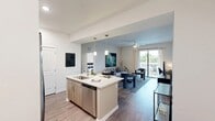 Located at 3260 Stockton Street in North Fort Myers, FL, this well-appointed 2-bedroom, 2-bathroom residence offers a thoughtfully designed single-floor layout. The open-concept kitchen and living area serves as the heart of the home, featuring a central island with a single-basin sink, stainless steel appliances including a side-by-side refrigerator, built-in microwave, electric range, and dishwasher, complemented by light wood cabinetry extending to the ceiling for ample storage. Pendant lighting illuminates the kitchen island, while wood-style flooring flows seamlessly throughout the main living areas. The living room is bright and inviting, anchored by a ceiling fan and sliding glass doors that open to a private balcony overlooking lush outdoor scenery. Both bedrooms are well-proportioned and comfortable, each featuring ceiling fans and natural light. The spacious primary bedroom includes a dedicated closet with wire shelving for organized storage. The two bathrooms are finished with light wood vanities, white quartz countertops, and large mirrors. A dedicated hallway and entrance area complete the functional layout, offering a cohesive and modern living environment ideal for everyday comfort in Southwest Florida.