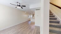 This two-story, 2-bedroom, 4-bathroom home in Clarksville, Tennessee offers a thoughtfully designed layout spread across two levels. The main floor opens into a combined kitchen and living area, where light-toned luxury vinyl plank flooring and a ceiling fan with integrated lighting create a bright, welcoming atmosphere. The kitchen is a standout feature, boasting gray shaker-style cabinetry with matte black hardware, crisp white quartz countertops, a peninsula with pendant lighting, stainless steel appliances, and a window above the sink that invites natural light. A convenient half bathroom on the main floor features wood-look flooring, a pedestal sink, and a round mirror with a matte black faucet. A dedicated laundry room with a stacked washer and dryer adds everyday practicality. Upstairs, the two bedrooms are carpeted for comfort, with windows providing natural light. The primary bedroom offers a generous footprint with a ceiling fan. The upper level also includes additional bathrooms, one of which features a full soaking tub and shower surround with built-in shelving. A hallway and closet round out the upper floor. The home's clean, neutral palette and modern finishes make it a move-in ready residence.