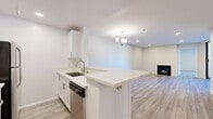 Located at 1223 Federal Ave in the desirable West Los Angeles neighborhood of 90025, this thoughtfully designed 2-bedroom, 2-bathroom residence offers a clean, contemporary aesthetic throughout its well-appointed single-floor layout. The open-concept living and kitchen area serves as the heart of the home, featuring light wood-look flooring, recessed lighting, and a sleek pendant chandelier. The kitchen is outfitted with crisp white shaker cabinetry, brushed nickel hardware, a marble-veined quartz peninsula with bar seating, a stainless steel sink, and a stainless steel dishwasher — all flowing seamlessly into the living room, which is anchored by a modern gas fireplace. The primary bedroom is a comfortable, well-proportioned retreat with a large sliding glass door that invites natural light and offers views of the surrounding neighborhood and hillside greenery. The second bedroom is similarly bright and clean, with neutral tones and wood-look flooring. Both bathrooms are finished in a fresh white palette, featuring quartz-topped white vanities with brushed nickel accents, gold-framed mirrors, and tub-shower combinations. Two closets and a hallway provide practical storage. The overall ambiance is bright, clean, and move-in ready.
