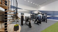Located in Atlanta, GA, this two-floor fitness facility offers a substantial and well-appointed space designed to support a full range of exercise disciplines. The design is immediately striking, with bold navy, grey, and white geometric murals spanning the walls and a dynamic athlete silhouette sculpture serving as a focal point — together creating an energizing, motivational atmosphere.

The lower floor is dedicated to strength training and specialty fitness. It features rubberized flooring throughout and is equipped with a comprehensive selection of resistance machines, dumbbell racks, weight benches, and a multi-functional cable rig. A standout feature is the Freedom Climber climbing wall, accompanied by a storage area for stability balls and fitness accessories. An artificial turf lane runs through the center of the floor, ideal for functional training and agility drills. A warm wood-slat partition adds a refined design element to the space.

A sculptural spiral staircase connects the lower floor to the upper level, which is bathed in natural light from large floor-to-ceiling windows offering outdoor views. Light hardwood flooring, a skylight, and a modern chandelier give this floor a bright, open feel. It is outfitted with treadmills, elliptical machines, rowing machines, and Peloton cycles — providing a full suite of cardio equipment. Ceiling fans and recessed lighting complete the space throughout both floors.