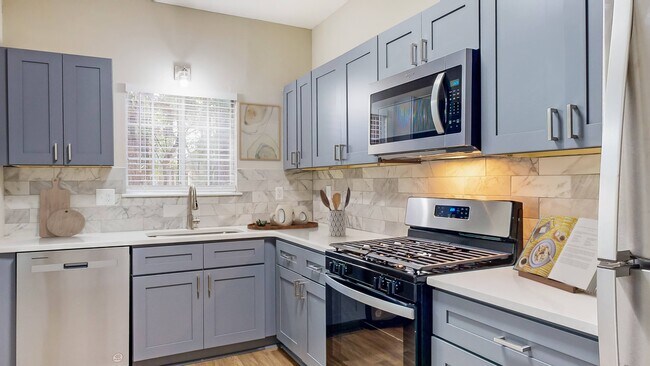 Cocina con electrodomésticos de acero inoxidable y encimeras de cuarzo - Creekside at White Oak