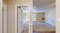 Located at 4327 N Chestnut St in Colorado Springs, Colorado, this single-floor unit offers a straightforward, functional layout well-suited for comfortable everyday living. The interior is finished with warm beige walls throughout, textured ceilings, and a combination of carpet and wood-look hard flooring that distinguishes the living and kitchen areas.

The open living area is generously proportioned, featuring carpet flooring, a ceiling fan with light fixture, and a baseboard heating system. It connects seamlessly to the kitchen, which is equipped with white cabinetry, dark-toned countertops, a double-basin sink, a white electric range, and a full-size refrigerator. A charming arched doorway adds a subtle architectural detail, leading to an additional entry or storage area.

The bedroom is a well-sized, carpeted room with natural light provided by a large window overlooking mature trees, contributing to a calm, private atmosphere. A baseboard heater ensures year-round comfort, and a wall-mounted air conditioning unit provides supplemental climate control.

The bathroom features a clean, tiled tub and shower combination with chrome fixtures. Throughout the unit, natural light filters in through multiple windows, offering pleasant views of the surrounding mature tree canopy.