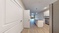 This well-appointed single-floor unit at 1105 Red Apple Rd in Wenatchee, Washington, offers a clean, modern aesthetic with thoughtful design details throughout. Light wood-tone flooring flows seamlessly across the open-concept layout, creating a cohesive and inviting atmosphere. The kitchen is a standout feature, showcasing white shaker-style cabinetry extending to the ceiling, dark speckled countertops, stainless steel appliances, and a peninsula with a stone-accented surface — ideal for casual dining or meal prep. A stylish pendant light anchors the kitchen-to-living transition, adding a contemporary touch. The living area is generously proportioned with vaulted ceilings and a large window and glass door that open directly to a private balcony. From the balcony, sweeping views of the surrounding mountains and open landscape provide a striking backdrop. The bedroom offers a comfortable retreat with dual closet doors and neutral-toned flooring, while the bathroom is finished with white cabinetry, a wide vanity mirror, brushed nickel fixtures, and a stone-top countertop. Throughout the unit, neutral wall tones, crisp white trim, and consistent flooring unify the space, creating a fresh and move-in-ready residence in the heart of Wenatchee.