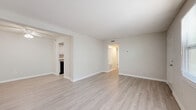 Located at 705 S Beach St in Daytona Beach, Florida, this single-floor, 2-bedroom, 2-bathroom unit offers a straightforward and functional layout designed for comfortable everyday living. Light wood-style vinyl flooring runs throughout the space, creating a cohesive and easy-to-maintain aesthetic across all rooms.

The dual living areas are bright and open, featuring neutral walls, textured ceilings, and ceiling fans that enhance airflow and comfort. Large windows in multiple rooms invite natural light and provide views of the surrounding neighborhood. The kitchen is equipped with white cabinetry, stone-patterned laminate countertops, a stainless steel sink, a dishwasher, and a range, offering practical functionality in a compact footprint.

The primary bedroom is a well-proportioned space with a ceiling fan and a closet with built-in rod shelving. The second bedroom is similarly appointed with a ceiling fan and a window, keeping the room bright and comfortable. Both bathrooms maintain a clean, utilitarian design — one features a full tub-shower combo with tile surround, while the other includes a vanity with an under-sink cabinet and a well-lit mirror. A dedicated closet provides additional storage. The unit's neutral palette and updated flooring create a move-in-ready environment throughout.