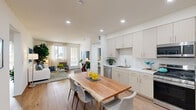 This well-appointed 2-bedroom, 2-bathroom residence offers a thoughtfully designed single-floor layout that maximizes comfort and functionality. The open-concept kitchen and living area serves as the heart of the home, featuring light wood-tone cabinetry, a white tile backsplash, stainless steel appliances including a French door refrigerator, and a sleek countertop that flows seamlessly into the dining area. A live-edge wood dining table anchors the space beneath recessed lighting, while warm hardwood-style flooring runs throughout. The living room is bathed in natural light from large sliding glass doors that open to the outdoors. Both bedrooms are well-sized, with the primary suite offering a walk-in closet and a private en-suite bathroom. The bathrooms are finished with striking marble-surround soaking tubs, light wood vanities, tile flooring, and built-in shelving for added storage. The second bedroom receives abundant natural light through large windows. Two dedicated closets provide generous storage throughout. Hallways connect the spaces efficiently, lending the layout a clean, organized flow. The overall aesthetic is modern and airy, with a neutral palette of whites, warm beiges, and natural wood tones creating a calm, inviting atmosphere throughout.