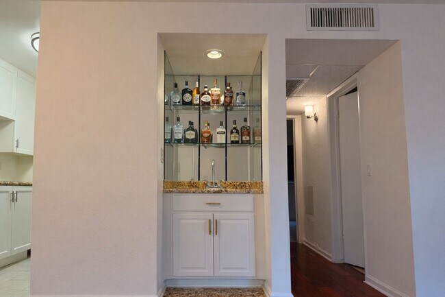 Barra de bar integrada con estantes de cristal espejado y encimera de granito: el sueño de cualquier anfitrión en West Hollywood. - 970 Palm Avenue
