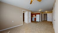 Located at 2726 East 12th Avenue in Winfield, Kansas, this single-floor unit offers a practical and comfortable layout designed for everyday living. The open living area is finished with neutral-toned carpet and warm beige walls, creating a welcoming atmosphere. A ceiling fan provides overhead circulation and lighting, while the entry door leads seamlessly into the main living space.

The kitchen flows directly off the living area and features warm wood-toned cabinetry, laminate countertops, and wood-look vinyl flooring. White appliances, including an electric range and refrigerator, are included, and a range hood overhead adds functionality to the cooking space.

The bedrooms are carpeted and finished in the same neutral palette, each offering closet storage with wire shelving systems for organized living. Natural light filters in through windows fitted with blinds, and vaulted ceiling lines in some rooms add a sense of openness.

The bathroom includes a full tub-shower combination, a wall-mounted sink, a medicine cabinet with mirror, and built-in shelving for additional storage. A separate area features wood-look plank flooring, a toilet, and a vanity with white cabinetry. Throughout the unit, consistent neutral tones and clean finishes create a cohesive, move-in-ready environment.