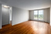 Located at 10 Overlea Dr in Kitchener, Ontario, this one-bedroom, one-bathroom unit offers a well-organized and efficiently designed layout. Warm hardwood-style flooring runs throughout the entire space, creating a cohesive and inviting atmosphere.

The open-concept living room is bright and airy, anchored by a large sliding window that frames a scenic view of the surrounding neighbourhood and lush greenery below. A baseboard heating unit runs beneath the window, ensuring year-round comfort. The space is clean and neutral, with crisp white walls that maximize the natural light.

The galley-style kitchen is thoughtfully appointed with white shaker-style cabinetry extending to the ceiling, offering generous storage. Light stone-toned countertops, a subway tile backsplash, a stainless steel sink, and a full suite of stainless steel appliances — including a refrigerator, electric range, and over-the-range microwave — complete this functional and modern cooking space.

The bedroom is a comfortable size, featuring a double-door closet for ample storage and a window that continues the natural light theme throughout the unit.

The bathroom is clean and classic, featuring a full soaker tub with tiled surround, a white vanity with storage, and chrome fixtures that lend a polished finish to the space.