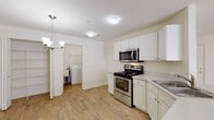 Located on Broadway Street in Novi, Michigan, this two-floor residence offers a well-organized layout across two levels. The kitchen is outfitted with white cabinetry, light countertops, and stainless steel appliances including an electric range with over-the-range microwave and a refrigerator. A peninsula with a sink provides a natural transition into the adjoining living area, and a dedicated laundry space with a washer is conveniently accessible nearby. The main living area is generously sized, featuring neutral carpet flooring, a fireplace, and a large window that draws in natural light and provides views of the surrounding community. A closet off the living space adds practical storage. The staircase leads to the upper floor, where multiple bedrooms are found, each carpeted and filled with natural light through sizable windows with blinds. The bathrooms are finished in neutral tones with tile flooring; one includes a soaking tub and vanity with storage, while another features a walk-in shower with sliding glass doors. Throughout the residence, the clean, light color palette and consistent finishes create a cohesive and comfortable atmosphere suited for everyday living.