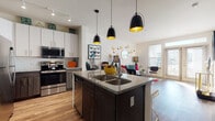 This thoughtfully designed 1-bedroom, 1-bathroom residence offers a cohesive open-concept floor plan that maximizes every square foot. The kitchen serves as the heart of the home, showcasing a large center island with granite countertops, a double sink, and seating for multiple bar stools. Two-tone cabinetry pairs white upper cabinets with dark lower cabinets, complemented by stainless steel appliances and a tile backsplash. Statement pendant lights with gold interiors hang above the island, adding a striking visual element. Wood-look flooring runs throughout the main living areas, creating a seamless flow from the kitchen into the dining and living spaces. The living room is bright and welcoming, featuring large windows and glass doors that invite ample natural light. The bedroom is generously sized with plush carpeting, multiple windows offering outdoor views, and a ceiling fan. The full bathroom features a soaking tub and shower combination with large-format tile surround, a granite-topped vanity with gold hardware, and wood-look flooring that ties into the rest of the home. Throughout the residence, clean lines and neutral walls provide a versatile backdrop for any style.