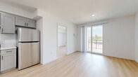 Located on N Van Nuys Blvd in Los Angeles, this modern 3-bedroom, 1-bathroom unit offers a clean, contemporary design throughout. Light wood-tone flooring runs continuously across the entire floor, complementing the crisp white walls and creating a bright, cohesive aesthetic.

The open living area connects seamlessly to the kitchen, which features stainless steel appliances and gray shaker-style cabinetry. Sliding glass doors lead to a private balcony, filling the living space with natural light and offering views of the surrounding neighborhood, including glimpses of palm trees and rooftops.

The generously sized primary bedroom includes its own sliding glass balcony door, a mirrored sliding closet, and abundant natural light from large windows overlooking the neighborhood. The additional bedrooms are well-proportioned, each featuring light flooring and ample natural light.

The bathroom is thoughtfully finished with gray shaker vanity cabinetry, a marble-style quartz countertop, a large framed mirror with black accents, and a full tub-shower combination with white tile surround.

Throughout the unit, recessed lighting, clean lines, and a neutral palette contribute to a modern and functional living environment well-suited for everyday comfort.