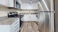 This recently renovated 890 square foot apartment offers a harmonious blend of modern amenities and comfortable living spaces. The unit features two bedrooms, including a spacious 200 square foot primary bedroom, and two full bathrooms. The heart of the home is a sleek, updated kitchen showcasing pristine white cabinetry, stainless steel appliances, and elegant granite countertops. The open-concept layout seamlessly connects the kitchen to a welcoming living area, complete with a charming fireplace that serves as a focal point. Throughout the apartment, you'll find a mix of durable wood-look flooring and plush carpeting, creating distinct zones for relaxation and daily activities. Large windows in the bedrooms and living spaces allow for ample natural light, while sliding glass doors in one room lead to an outdoor area, extending the living space. The bathrooms are tastefully appointed with modern fixtures and finishes, including a vanity with a granite countertop. This thoughtfully designed apartment offers a perfect balance of style and functionality, ideal for comfortable urban living.