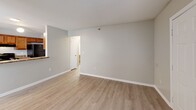 Located at 2404 Hill St in Raleigh, NC, this single-floor residence offers three bedrooms and two full bathrooms within a well-organized, functional layout. The combined kitchen and living area forms the heart of the home, featuring light hardwood-style flooring that carries throughout the main living spaces. The kitchen is equipped with warm wood cabinetry, granite-style countertops, black appliances including a refrigerator, electric range, and dishwasher, along with a peninsula with a built-in sink that opens toward the living area. The living room is bright and open, with a front-facing window that brings in natural light and provides views of the surrounding outdoor space. A hallway connects the main living area to the three bedrooms, each finished with plush carpet and neutral wall tones. The primary bedroom offers a comfortable footprint with natural light from a window. The two bathrooms are each outfitted with a full tub-shower combination and clean, white fixtures. Textured ceilings are present throughout, and the overall color palette of soft grays and warm neutrals lends the space a calm, cohesive atmosphere. This residence provides a practical and comfortable layout well-suited for everyday living in Raleigh.