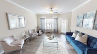 This single-story residence located at 129–155 N Roaring Springs Rd in Westworth Village, Texas, offers a well-organized layout with cohesive design elements throughout. The living room serves as the heart of the space, featuring crown molding, a ceiling fan, wood-style flooring, and multiple windows with blinds that allow ample natural light. A private exterior door in the living area provides convenient outdoor access.

An adjoining area functions effectively as a dining or sitting space, maintaining the same wood-style flooring and crown molding detail, lending the common areas a unified, polished feel. The kitchen is equipped with stainless steel appliances—including a refrigerator, range, and over-the-range microwave—complemented by white shaker-style cabinetry and granite-look countertops, creating a clean and functional workspace.

The bedrooms are carpeted for comfort and receive natural light through window treatments. The primary bedroom is notably spacious, offering room for generous furnishings. The bathroom includes a tub-shower combination, white cabinetry with overhead storage, granite-look counters, and a well-lit vanity mirror. Neutral wall tones and consistent finishes throughout the residence contribute to a calm, cohesive overall ambiance.