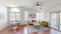 Located at 647 West Baseline Road in Tempe, Arizona, this two-story townhome offers a well-designed layout across two floors. The main level features a bright, open-concept living and dining area beneath striking vaulted ceilings, highlighted by an arched window and multiple large windows that flood the space with natural light. Wood-look flooring runs throughout the main level, adding warmth to the interior. A ceiling fan adds comfort to the living area, which also provides access to a private balcony through sliding glass doors. The kitchen is outfitted with warm wood cabinetry, light countertops, black appliances including a range, microwave, dishwasher, and refrigerator, complemented by ample cabinet storage. A dedicated laundry area with in-unit washer is conveniently located on the main floor. Upstairs, the spacious primary bedroom features carpet flooring, a ceiling fan, and a well-sized walk-in closet with built-in shelving and dual hanging rods. A second bedroom with a built-in closet serves well as a home office. The shared full bathroom includes a dual-sink vanity with wood cabinetry, light countertops, a shower-tub combination, and wood-look flooring. Hallways connecting the upper level are bright and well-appointed, completing this functional and stylish Tempe townhome.