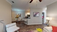 Located at 8100 US 98 in Pensacola, Florida, this single-floor residence offers a thoughtfully designed open-concept layout with modern finishes and a bright, welcoming atmosphere. The living area features rich wood-look flooring, crown molding, a ceiling fan, and large windows that allow abundant natural light to fill the space. A vibrant area rug and generous layout make this room ideal for both relaxing and entertaining.

The dining area flows seamlessly from the living room and is accented by a pendant light fixture, crown molding, and wood-look flooring, creating an intimate yet connected space. Adjacent to the dining area, the kitchen features white cabinetry, dark granite countertops, black appliances, and a breakfast bar with bar seating — combining functionality with contemporary style.

The bedrooms are carpeted and well-proportioned, each featuring ceiling fans and windows dressed with sheer curtains and blinds that invite soft, natural light. One bedroom includes a walk-in closet. A dedicated home office provides a quiet, light-filled workspace with carpet flooring and a large window.

The bathroom is finished with dark granite countertops, white cabinetry, a large vanity mirror with overhead lighting, and a full tub-shower combination with wood-look flooring that ties the space together cohesively throughout.