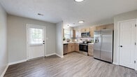 Located at 2358 Sterlington Rd in Lexington, Kentucky, this single-story, 3-bedroom, 2-bathroom home offers a well-designed layout with modern finishes throughout. The updated kitchen is a standout feature, boasting light wood shaker-style cabinetry, white quartz countertops, a subway tile backsplash, and a full suite of stainless steel appliances including a dishwasher, range, microwave, and French door refrigerator. A window above the sink allows natural light to brighten the space. The kitchen opens to a living area finished with durable light-toned luxury vinyl plank flooring that continues through the main living spaces, giving the home a clean and cohesive feel. The spacious primary bedroom offers generous proportions, while all three bedrooms feature plush carpeting, ceiling fans with light fixtures, and ample natural light from windows. Closets provide practical storage in the secondary bedrooms. The two bathrooms are finished with wood-tone vanities and marble-look countertops, with matte black hardware accents adding a modern touch. One bathroom includes a tub-shower combination. Neutral gray walls and textured ceilings carry throughout, creating a calm and inviting ambiance suited for comfortable everyday living.