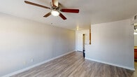 Located at 1500 East Broadway Road in Tempe, Arizona, this single-floor, one-bedroom, two-bathroom unit offers a well-organized and functional layout. The living room is bright and open, featuring wood-look plank flooring, neutral gray walls, a ceiling fan with light fixture, and a window that brings in natural light. The space flows into a combined dining and kitchen area, where warm wood cabinetry, granite countertops, track lighting, and a full suite of black and stainless steel appliances — including a range, built-in microwave, dishwasher, and refrigerator — create a practical and attractive cooking environment. An in-unit washer is also conveniently tucked within the kitchen area. A pantry provides additional storage. The bedroom is a comfortable size, with wood-look flooring, neutral tones, and a window overlooking the outdoors. Two closets offer ample storage throughout the unit. Both bathrooms feature granite-topped wood vanities with large mirrors and wood-look flooring; one bathroom includes a full shower-tub combination. A hallway connects the private areas of the home. Clean finishes and consistent flooring throughout give the unit a cohesive, move-in-ready feel.