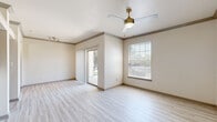 This single-floor, 2-bedroom, 1-bathroom residence offers a thoughtfully designed layout with modern finishes throughout. The open living area features light wood-look flooring, crown molding, and a ceiling fan with a built-in light fixture. Natural light fills the space through multiple windows fitted with horizontal blinds, while sliding glass doors lead out to a private balcony, seamlessly connecting indoor and outdoor living.

The galley-style kitchen is well-equipped with rich dark cabinetry, granite countertops, a tile backsplash, stainless steel appliances, and a deep double sink. Adjacent to the kitchen is a convenient in-unit laundry area. Built-in shelving adds practical storage to the common areas.

Both bedrooms are carpeted for comfort and include ceiling fans and windows that bring in natural light. The primary bedroom offers a generous footprint with ample room for furnishings.

The bathroom is finished with dark espresso cabinetry, granite countertops, a large framed mirror, and modern vanity lighting. The space also includes a shower and matching dark cabinetry for additional storage. Throughout the residence, the neutral color palette and consistent finishes create a clean, cohesive, and inviting atmosphere.