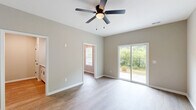 Located at 1111 Elk Knob Trl in Fayetteville, NC, this two-story home offers 3 bedrooms, 4 bathrooms, and a thoughtfully designed layout spread across two floors. The main level features a living room with light wood-look flooring, a ceiling fan, and a sliding glass door that opens to the outdoors with lush greenery views. The kitchen is equipped with white shaker cabinetry, granite-look countertops, stainless steel appliances including an electric range and over-the-range microwave, and a classic subway tile backsplash. A dedicated dining room and a convenient laundry room with wire shelving and appliance hookups complete the first floor, alongside an attached garage with an automatic opener. Upstairs, the three bedrooms offer plush carpeting, ceiling fans, and ample natural light through vinyl-framed windows with blinds. The spacious primary bedroom features a sliding glass door and direct access to its own bathroom and walk-in closet with wire shelving. Additional bedrooms share well-appointed bathrooms. Throughout, neutral warm-gray walls, white trim with wainscoting accents in the hallways, and consistent finishes create a clean, cohesive aesthetic. Seven closets throughout the home ensure exceptional storage capacity.