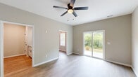 Located at 1111 Elk Knob Trl in Fayetteville, NC, this two-story home offers 3 bedrooms, 4 bathrooms, and a thoughtfully designed layout spread across two floors. The main level features a living room with light wood-look flooring, a ceiling fan, and a sliding glass door that opens to the outdoors with lush greenery views. The kitchen is equipped with white shaker cabinetry, granite-look countertops, stainless steel appliances including an electric range and over-the-range microwave, and a classic subway tile backsplash. A dedicated dining room and a convenient laundry room with wire shelving and appliance hookups complete the first floor, alongside an attached garage with an automatic opener. Upstairs, the three bedrooms offer plush carpeting, ceiling fans, and ample natural light through vinyl-framed windows with blinds. The spacious primary bedroom features a sliding glass door and direct access to its own bathroom and walk-in closet with wire shelving. Additional bedrooms share well-appointed bathrooms. Throughout, neutral warm-gray walls, white trim with wainscoting accents in the hallways, and consistent finishes create a clean, cohesive aesthetic. Seven closets throughout the home ensure exceptional storage capacity.