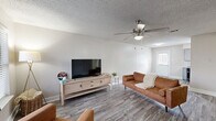 Located in Crowley, TX, this two-story home offers 2 bedrooms and 3 bathrooms across two well-proportioned floors. The main level features a welcoming living room with wood-look plank flooring, neutral gray walls, a ceiling fan, and a window that invites natural light. The galley-style kitchen is thoughtfully designed with gray cabinetry, granite-style countertops, a subway tile backsplash, a double sink, and black appliances including a refrigerator, range, and dishwasher. A staircase connects the main level to the upper floor, which houses the bedrooms and additional bathrooms. The spacious primary bedroom features wood-look flooring, a ceiling fan with light kit, and a window with outdoor views. The second bedroom offers a clean, neutral palette with matching flooring. All three bathrooms are consistently appointed with gray vanity cabinets, granite-style countertops, large mirrors, and modern brushed-nickel fixtures. At least one bathroom includes a shower-tub combination. Textured ceilings are featured throughout the home. The exterior reveals a modest yard with surrounding greenery, providing a private outdoor setting. The home combines practical functionality with a cohesive, contemporary aesthetic throughout.