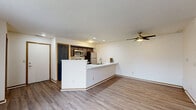 Located at 75 N Orchard Dr in Warsaw, Indiana, this single-floor, 3-bedroom, 2-bathroom home offers a practical and comfortable layout. The open-concept living and kitchen area forms the heart of the home, centered around a peninsula with a white countertop and double sink, dark cabinetry, and stainless steel appliances including a range, microwave, and refrigerator. Recessed lighting and a ceiling fan keep the space bright and well-ventilated. The living area features durable hardwood-style flooring and a sliding glass door that opens to a private balcony, bringing in natural light and outdoor views. The three bedrooms are carpeted for comfort, each with neutral walls and windows fitted with blinds. The primary bedroom is a well-proportioned retreat with direct access to a closet. Both bathrooms are cleanly appointed — one features a dark-cabinetry vanity with framed mirror and a shower/tub combination, while the second offers a white vanity with a large mirror. Textured ceilings, warm wood-toned trim, and a consistent neutral color palette give the home a cohesive, move-in-ready feel throughout.