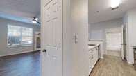This single-floor residence offers a thoughtfully designed layout with modern finishes throughout. The open living and dining area is bright and welcoming, featuring rich wood-look vinyl flooring, crown molding, a ceiling fan, and multiple windows dressed with horizontal blinds that allow generous natural light. A glass-paneled door leads directly to a private balcony, extending the living space outdoors.

The kitchen is outfitted with crisp white cabinetry, marble-look quartz countertops, a subway tile backsplash, and stainless steel appliances including a range, over-the-range microwave, and dishwasher. A convenient pass-through layout connects the kitchen seamlessly to the main living area.

The bedrooms are carpeted for comfort and feature neutral tones, ample natural light from well-positioned windows, and generous closet space. One bedroom includes a walk-in closet with built-in shelving, providing excellent storage.

The bathroom is clean and functional, showcasing wood-look vinyl flooring, a white vanity with quartz-style countertop, a large mirror, and a full tub-shower combination with tiled surround. Throughout the space, consistent neutral gray walls, white trim, and textured ceilings contribute to a cohesive, contemporary aesthetic.
