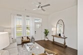 This two-story residence in Hoover, Alabama, offers a thoughtfully designed layout spread across two floors. The main level features an open-concept living and kitchen area bathed in natural light from large windows dressed with sheer white curtains. The living room is anchored by wood-look flooring, a ceiling fan, and a welcoming front entry with transom window. The kitchen is a standout, showcasing gray shaker-style cabinetry, gleaming white quartz countertops, a large island with bar seating for four, pendant lighting, and a full suite of stainless steel appliances. A dedicated laundry room on the main floor includes a full-size washer and dryer with a window for natural light and built-in shelving. The upper floor houses both bedrooms, each featuring ceiling fans, wood-look flooring, natural light, and ample closet space. The spacious primary bedroom offers generous proportions and a serene, neutral palette. Both bathrooms are finished with gray vanities, white quartz countertops, and wood-look tile flooring. One bathroom features a tub-shower combination with a bright window. Throughout, the home maintains a clean, contemporary aesthetic with neutral tones and consistent finishes.