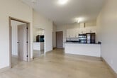Located at 847 Development Drive in Kingston, Ontario, this well-appointed one-bedroom, one-bathroom unit offers a thoughtfully designed open-concept layout finished with contemporary details throughout. Light-toned hardwood flooring flows seamlessly across the entire unit, enhancing the bright and airy atmosphere created by neutral wall tones and generous ceiling height.

The combined living, dining, and kitchen area forms the heart of the unit. The kitchen is outfitted with crisp white shaker-style cabinetry, dark quartz countertops, a peninsula with additional counter space, and a full suite of stainless steel appliances including a range, built-in microwave, and refrigerator. The open layout allows the kitchen to flow naturally into the living and dining areas.

The bedroom is a comfortable and well-proportioned retreat, featuring a sliding glass door that opens onto a private balcony with outdoor views. A built-in closet with shelving and drawers provides ample organized storage, while an additional closet offers further space.

The bathroom is finished to a high standard, with marble-look tile flooring, a dark quartz vanity with white cabinetry, a frameless glass walk-in shower, and in-unit laundry hookups — combining practicality with refined style throughout.