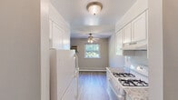 Located at 1717 Bath Rd in Bristol, PA, this one-bedroom, one-bathroom unit offers a practical and well-appointed single-floor layout. Light wood-style flooring runs throughout, complementing the neutral gray walls and white trim that give the space a clean, cohesive feel. The galley-style kitchen flows directly into the dining area and features white cabinetry with granite-look countertops, a gas range, and a full-size refrigerator, all illuminated by a flush ceiling light. The adjoining living and dining area is bright and open, benefiting from multiple windows that frame lush, green outdoor views, with a ceiling fan and baseboard heating ensuring year-round comfort. The spacious primary bedroom includes its own window with natural light, a closet with built-in shelving, and the same hardwood-style flooring found throughout. A second closet provides additional storage. The bathroom is notably updated, featuring large marble-style wall and floor tiles, a white vanity, and a window for natural ventilation. Two hallways connect the rooms efficiently, rounding out a functional and well-maintained living space.