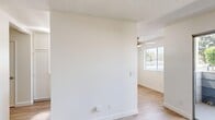 Located at 266 N El Camino Real in Oceanside, California, this one-bedroom, one-bathroom unit offers a thoughtfully designed single-level layout. Light wood-style flooring runs throughout the main living areas, complemented by neutral white walls and textured ceilings that lend a clean, bright aesthetic. The living room is generously proportioned for the overall footprint and features a ceiling fan, natural light from a window, and a seamless flow into the dining area. The galley-style kitchen is well-appointed with white upper and lower cabinetry reaching nearly to the ceiling, light countertops, a stainless steel refrigerator, dishwasher, and a black range, along with a window that brings in additional natural light. A dedicated dining space adjoins the kitchen, offering a practical area for everyday meals. The bedroom is carpeted for comfort, features sliding mirrored closet doors providing ample storage, and includes a window with blinds for natural light and privacy. The full bathroom is finished in white with a tub-shower combination, a vanity with white cabinetry, and wood-style flooring. Additional storage is provided by two closets, and a private balcony extends the living space outdoors.