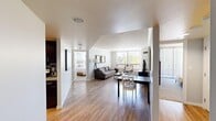 Located in Denver's vibrant Washington Park neighborhood, this three-bedroom, two-bathroom residence offers a well-designed single-floor layout. The open-concept living and dining area serves as the heart of the home, featuring light hardwood flooring, neutral walls, and large windows that flood the space with natural light and provide lush greenery views. The galley-style kitchen is outfitted with dark espresso cabinetry, granite countertops, a mosaic tile backsplash, and a full suite of stainless steel appliances, combining style with functionality. The primary bedroom is a comfortable retreat, complete with plush carpeting, a large sliding glass door opening to a private balcony with tree-lined views, and a dedicated closet with built-in shelving. Additional bedrooms are bright and well-proportioned, each featuring large windows and soft carpet. The two bathrooms are finished with dark wood vanities, granite countertops, and modern light fixtures. A dedicated closet provides extra storage. Throughout the residence, the cohesive design palette of warm wood tones and light neutrals creates an inviting and functional living environment.