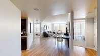 Located in Denver's vibrant Washington Park neighborhood, this three-bedroom, two-bathroom residence offers a well-designed single-floor layout. The open-concept living and dining area serves as the heart of the home, featuring light hardwood flooring, neutral walls, and large windows that flood the space with natural light and provide lush greenery views. The galley-style kitchen is outfitted with dark espresso cabinetry, granite countertops, a mosaic tile backsplash, and a full suite of stainless steel appliances, combining style with functionality. The primary bedroom is a comfortable retreat, complete with plush carpeting, a large sliding glass door opening to a private balcony with tree-lined views, and a dedicated closet with built-in shelving. Additional bedrooms are bright and well-proportioned, each featuring large windows and soft carpet. The two bathrooms are finished with dark wood vanities, granite countertops, and modern light fixtures. A dedicated closet provides extra storage. Throughout the residence, the cohesive design palette of warm wood tones and light neutrals creates an inviting and functional living environment.