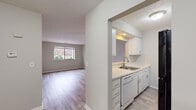 This single-floor unit at 4979 Kings Highland Dr W in Columbus, Ohio, offers a practical and well-organized layout with a clean, neutral aesthetic. The interior is finished with wood-look laminate flooring throughout the main living areas, providing a cohesive and easy-to-maintain surface that runs from the entry hallway through the living and dining spaces.

The kitchen is positioned adjacent to the living area and features white cabinetry, light countertops, a stainless steel sink, a dishwasher, and a black refrigerator. A pass-through window connects the kitchen to the living room, enhancing the open feel between the two spaces. The living room is generously sized, equipped with a ceiling fan, and receives natural light through a large window overlooking the surrounding greenery.

The bedrooms are carpeted and similarly bright, each featuring windows with outdoor views of the landscaped grounds. The textured ceilings are consistent throughout the unit, adding a subtle design element to the otherwise clean, minimal interiors.

The bathroom includes a full tub and shower combination, a single vanity with a mirror, and tile flooring. White cabinetry and chrome fixtures maintain the unit's consistent, understated palette. Overall, the space presents a functional and move-in ready environment suited for comfortable everyday living.