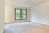 Located at 6309 Lakeview Blvd in Middleton, WI, this single-floor, three-bedroom, one-bathroom home offers a practical and comfortable layout. The living areas feature a combination of plush carpeting and warm hardwood flooring, creating a welcoming atmosphere throughout. Two distinct living room areas provide flexible space for lounging or dining.

The kitchen is equipped with oak cabinetry, generous counter space, and a full-size refrigerator, with tile flooring that transitions seamlessly into the carpeted living areas. Each of the three bedrooms features hardwood floors, ceiling fans, and sliding double-door closets offering abundant storage. Several bedrooms include windows that let in natural light and provide views of the surrounding greenery.

A central hallway connects the bedrooms to the shared full bathroom, which includes a vanity with a large countertop sink, wood cabinetry, and a medicine cabinet mirror. With six closets throughout, storage is plentiful. The home also includes an entrance area and a private patio, ideal for outdoor relaxation. The neutral color palette and classic wood accents give this home a clean, timeless character.