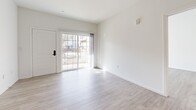 Located at 177 N Myrtle Ave in Pomona, California, this single-story residence offers three bedrooms and three bathrooms within a thoughtfully designed open floor plan. Light wood-look flooring flows consistently throughout, complementing the bright white walls and creating a clean, cohesive aesthetic.

The open-concept kitchen, dining, and living area serves as the heart of the home. The kitchen is equipped with stainless steel appliances — including a refrigerator, range, microwave, and dishwasher — paired with white shaker cabinetry and granite countertops that extend across a peninsula, providing both workspace and a casual dining option. Recessed lighting illuminates the kitchen, while the living area benefits from natural light streaming through sliding glass doors that open to an outdoor patio.

The three bedrooms are well-proportioned, each featuring wood-look flooring and ample natural light. The primary bedroom includes sliding glass door access to an outdoor balcony or patio. The bathrooms are finished with granite-topped vanities, white cabinetry, and tub-shower combinations equipped with accessibility grab bars. Additional highlights include five closets, a dedicated laundry area, a utility room, and two hallways that efficiently connect the living spaces throughout the home.