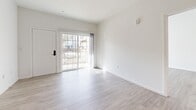 Located at 177 N Myrtle Ave in Pomona, California, this single-story residence offers three bedrooms and three bathrooms within a thoughtfully designed open floor plan. Light wood-look flooring flows consistently throughout, complementing the bright white walls and creating a clean, cohesive aesthetic.

The open-concept kitchen, dining, and living area serves as the heart of the home. The kitchen is equipped with stainless steel appliances — including a refrigerator, range, microwave, and dishwasher — paired with white shaker cabinetry and granite countertops that extend across a peninsula, providing both workspace and a casual dining option. Recessed lighting illuminates the kitchen, while the living area benefits from natural light streaming through sliding glass doors that open to an outdoor patio.

The three bedrooms are well-proportioned, each featuring wood-look flooring and ample natural light. The primary bedroom includes sliding glass door access to an outdoor balcony or patio. The bathrooms are finished with granite-topped vanities, white cabinetry, and tub-shower combinations equipped with accessibility grab bars. Additional highlights include five closets, a dedicated laundry area, a utility room, and two hallways that efficiently connect the living spaces throughout the home.