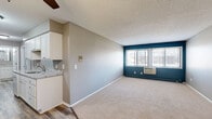 This two-bedroom, one-bathroom unit at 1337 Centennial Dr in Farmington, MN offers a practical and well-organized layout across a single floor. The galley-style kitchen is a standout feature, showcasing white shaker cabinetry, granite-look countertops, stainless steel appliances including a range and refrigerator, and durable wood-look vinyl plank flooring. A ceiling fan overhead adds functionality to the space, which flows directly into the living area.

The living room is carpeted and features a bold teal accent wall with a wide multi-pane window that draws in natural light and provides outdoor views. A wall-mounted HVAC unit offers in-unit climate control. The space transitions smoothly from the hard-surface kitchen into the carpeted living area, creating a clear delineation between zones.

Both bedrooms are finished with neutral gray walls and plush carpet. The primary bedroom includes a double-door closet, textured ceiling, and baseboard heating. The second bedroom features a window with natural light and a baseboard heater as well. The bathroom includes a full tub/shower combo with brushed nickel fixtures. Throughout the unit, clean white trim and a consistent neutral palette create a cohesive, move-in ready environment.