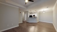 Located at 2405 W Omaha St in Tulsa, Oklahoma, this single-story residence offers a thoughtfully designed open-concept floor plan with consistent hardwood-style flooring extending throughout every room. The living area is generously proportioned, featuring a tray ceiling detail, ceiling fan, and crown molding that add architectural interest. Neutral gray walls create a clean, contemporary backdrop that carries seamlessly through the entire unit.

The kitchen is a functional centerpiece of the space, featuring white shaker-style cabinetry with brushed nickel hardware, granite-look countertops, and black appliances including a refrigerator, electric range, and built-in microwave. Pendant lighting above the breakfast bar peninsula and track lighting above provide both task and ambient illumination.

The bedrooms are well-sized, each equipped with ceiling fans and windows that allow natural light to filter in. The bathroom is finished with a granite-topped vanity, white cabinetry, and a tub-shower combination with clean, neutral tile surround.

A dedicated laundry room with hardwood-style flooring houses a full-sized washer and dryer and includes wire shelving for additional storage. The overall ambiance of the space is modern, clean, and move-in ready.