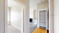 Located at 900 W Franklin St in Richmond, Virginia, this 2-bedroom, 1-bathroom residence showcases classic architectural character throughout its well-organized single-floor layout. The space features a mix of hardwood and luxury vinyl plank flooring in the main living and second bedroom areas, while plush carpeting adds warmth to the primary bedroom and hallway.

The primary bedroom is generously sized and bathed in natural light through multiple striking arched windows, offering elevated views of the surrounding Richmond cityscape. A cast-iron radiator provides classic heating, complemented by a window AC unit. The second bedroom also features an arched window and durable vinyl plank flooring, creating a bright and functional space.

A hallway connects the rooms and includes built-in shelving for added storage convenience. The living area features original hardwood floors and a fireplace, adding historic charm to the unit. The bathroom retains its period character with classic white hex tile flooring, a full soaking tub with shower, pedestal sink, radiator, and a window for natural ventilation. Additional storage is provided through a dedicated closet with shelving and a hanging rod. Neutral warm-toned walls throughout create a cohesive and inviting ambiance that complements the building's historic character.