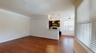 Located at 1300 Sterling Green Dr in Cary, NC, this single-floor residence offers a well-designed layout highlighted by warm hardwood flooring that extends consistently throughout every room. The open-concept living and dining area is generously proportioned, featuring crown molding along the ceiling perimeter and large windows that invite abundant natural light and views of the surrounding greenery. A ceiling fan with a light kit serves the dining area, contributing to both comfort and functionality.

The kitchen is positioned at the heart of the space, defined by a peninsula with granite countertops that creates a natural divide between the kitchen and living areas. Dark espresso cabinetry reaches toward the ceiling, providing ample storage, while a subway tile backsplash adds a clean, modern detail. Stainless steel appliances, including an over-the-range microwave and electric range, complete the kitchen's practical setup. Pendant lighting above the peninsula adds a stylish accent.

The bedrooms are spacious and bright, each equipped with ceiling fans and windows framing wooded outdoor views. Two full bathrooms serve the residence, both featuring dark vanity cabinetry with white countertops and tub-shower combinations with tile or smooth surrounds. The consistent hardwood flooring in the bathrooms ties the overall aesthetic together, creating a cohesive and polished feel throughout the home.