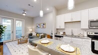 This thoughtfully designed 1-bedroom, 1-bathroom residence offers an efficient and comfortable single-level layout. The open-concept kitchen and living area form the heart of the unit, creating a seamless flow ideal for everyday living. The kitchen is outfitted with crisp white shaker cabinetry, granite countertops, a subway tile backsplash, stainless steel appliances, and a peninsula island with bar seating illuminated by pendant lighting — a functional and stylish space for cooking and casual dining. The living room features warm wood-look flooring, a ceiling fan, and a set of French doors that invite abundant natural light and provide outdoor access. The bedroom offers a comfortable, private retreat with plush carpet, a ceiling fan, a window with natural light, and a barn-style sliding door leading to the dedicated closet, which includes wire shelving for organized storage. The bathroom is finished with white cabinetry and wood-look flooring, conveniently adjacent to the closet. Throughout the unit, a neutral color palette, recessed lighting, and consistent modern finishes create a clean, cohesive ambiance that is both inviting and practical.