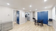 Located at 54 Cheney Dr in Storrs Mansfield, CT, this one-bedroom, one-bathroom unit offers a efficiently designed single-floor layout with modern updates throughout. Light wood laminate flooring runs continuously through all rooms, creating a cohesive and clean aesthetic.

The main living and dining area is the largest space in the unit, anchored by a bold blue entry door with a transom window that introduces natural light. Recessed lighting illuminates the open area, which accommodates both a dining table and living room seating. The space connects directly to the galley-style kitchen, which features gray shaker cabinets, granite countertops, a hexagonal tile backsplash, stainless steel appliances including a refrigerator and electric range, and an undermount sink.

The living room is a separate, well-lit room with paneled walls, recessed lighting, a window with blinds, and a wall-mounted thermostat. The bedroom is a cozy, naturally lit room with paneled walls and a window, providing a quiet retreat. The bathroom is stylishly finished with large-format wall tiles, a wood-tone accent tile band, a glass-panel shower enclosure with a black frame, and tile flooring, giving it a contemporary feel.