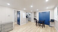 Located at 54 Cheney Dr in Storrs Mansfield, CT, this one-bedroom, one-bathroom unit offers a efficiently designed single-floor layout with modern updates throughout. Light wood laminate flooring runs continuously through all rooms, creating a cohesive and clean aesthetic.

The main living and dining area is the largest space in the unit, anchored by a bold blue entry door with a transom window that introduces natural light. Recessed lighting illuminates the open area, which accommodates both a dining table and living room seating. The space connects directly to the galley-style kitchen, which features gray shaker cabinets, granite countertops, a hexagonal tile backsplash, stainless steel appliances including a refrigerator and electric range, and an undermount sink.

The living room is a separate, well-lit room with paneled walls, recessed lighting, a window with blinds, and a wall-mounted thermostat. The bedroom is a cozy, naturally lit room with paneled walls and a window, providing a quiet retreat. The bathroom is stylishly finished with large-format wall tiles, a wood-tone accent tile band, a glass-panel shower enclosure with a black frame, and tile flooring, giving it a contemporary feel.