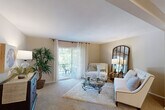 This thoughtfully laid-out residence in Saint Louis, Missouri features three bedrooms, one bathroom, and a single-floor plan that makes efficient use of every square foot. The inviting living room is bathed in natural light from a sliding glass door that opens to a private balcony, offering pleasant outdoor views. Plush carpeting, neutral warm-toned walls, and generous proportions give the space a comfortable, welcoming ambiance. Adjacent to the living room, the dining area features a ceiling fan and carpeted flooring, providing a cozy setting for meals. The galley-style kitchen is outfitted with warm wood cabinetry, a double sink, white appliances including a dishwasher, range, and refrigerator, and easy-care tile flooring. The primary bedroom is a well-sized retreat, while the additional bedrooms offer flexibility for guests or a home office, each with carpeted floors and natural light from windows. A hallway with closet storage connects the living spaces to the bedrooms. The full bathroom features tile flooring, a tub-shower combination with white tile surround, a wide vanity with ample cabinet storage, and a large mirror with overhead lighting. Throughout, the neutral color palette and carpet flooring create a cohesive, serene atmosphere.