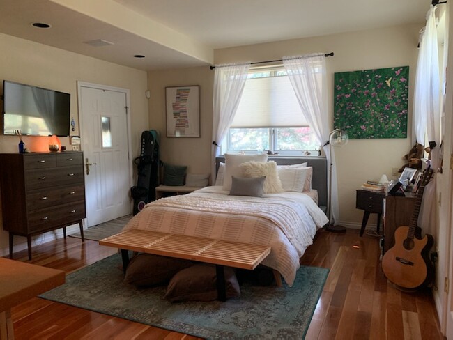 Bed area with Entry Door & Wall Mount TV. This is how 1 tenant setup the apartment. - 46 Heather Ln